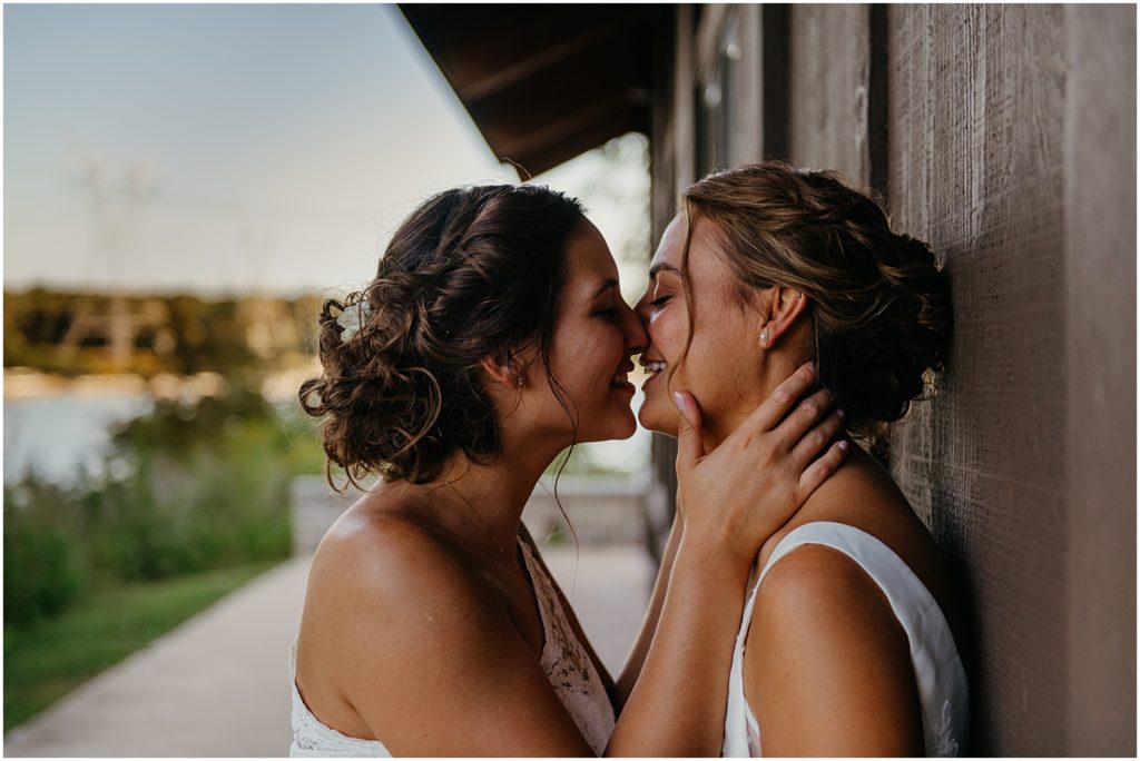 two brides passionately kissing during their intimate wedding during the fall